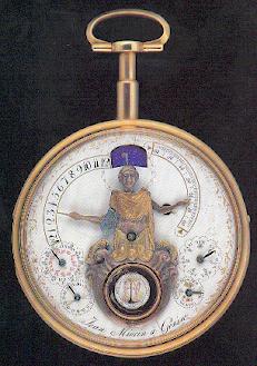 Montre à automate dite "bras en l'air" du début du 19ème siècle. Le personnage indique dans un mouvement continu avec le bras de gauche les heures et le bras de droite les minutes. Lorsque qu'un bras arrive à l'extrémité de la graduation, il redescend instantanéement en position de départ. La tête du personnage se tourne de gauche à droite au rythme des secondes. A ses pieds, la troteuse en forme de serpent tourne autour d'un médaillon représentant Adam et Eve devant l'arbre de vie. Les quatres petits cadrans indiquent les saisons, jours, quantièmes et mois avec leur nombre de jours respectifs. L'âge de la lune est indiqué dans le guichet situé au-dessus de la tête du personnage.  Source AFAHA Besançon/Musée des Monts - Le Locle.